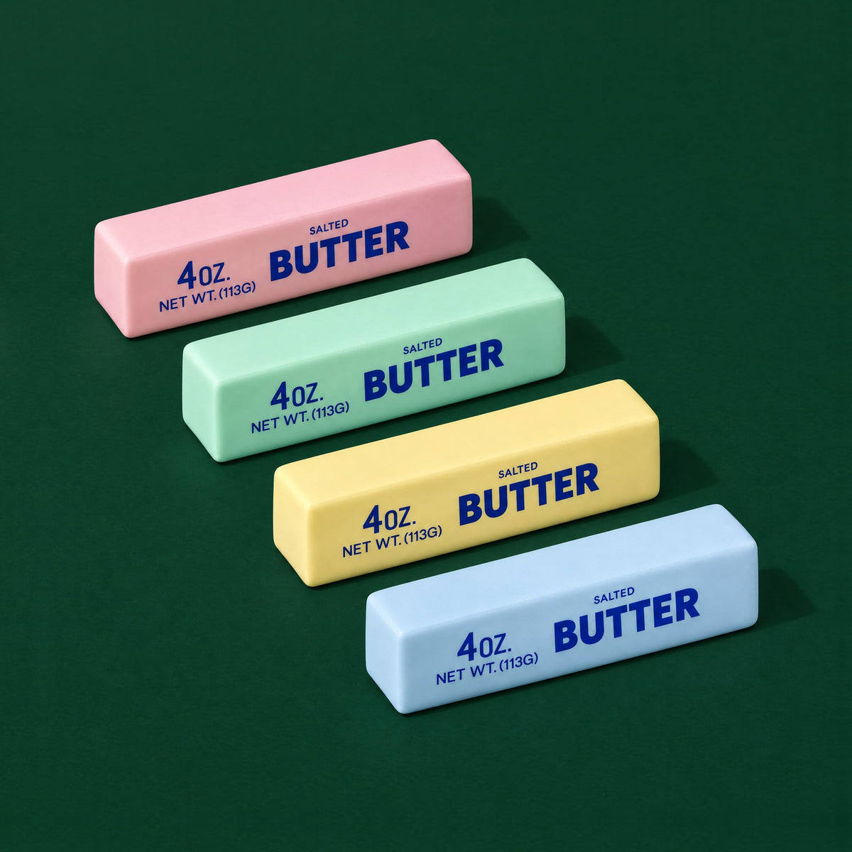 Pink, mint, yellow and blue Crunch Butter squishy blocks printed 4oz Salted Butter, in a row on dark green
