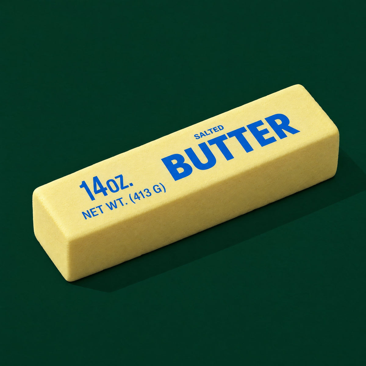 The Jumbo Butter: a 24 cm pale yellow foam squishy printed 14 oz. Salted Butter, lying at an angle on dark green