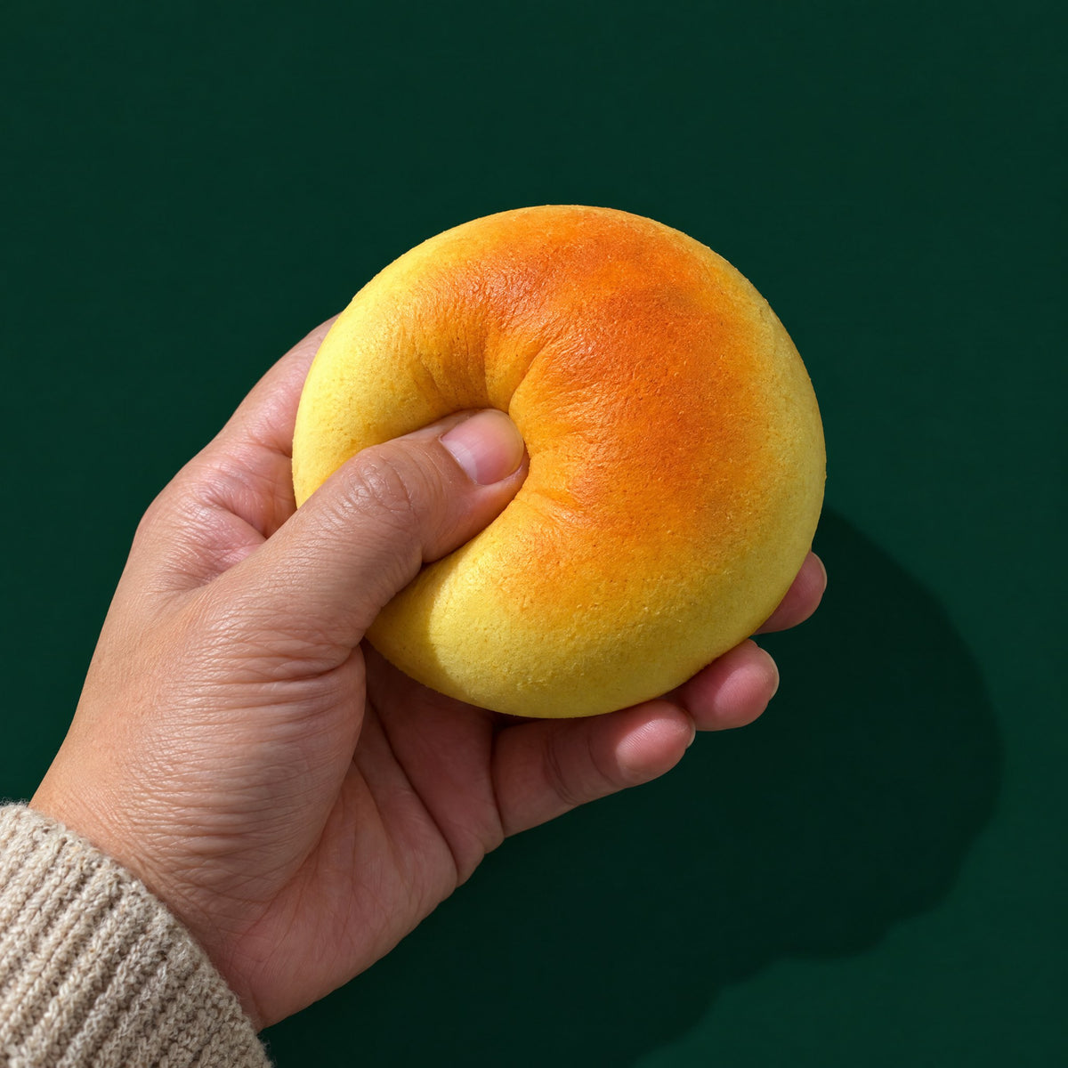 An adult hand presses a deep dent into a Mystery Bake bun (one example style; yours is random).