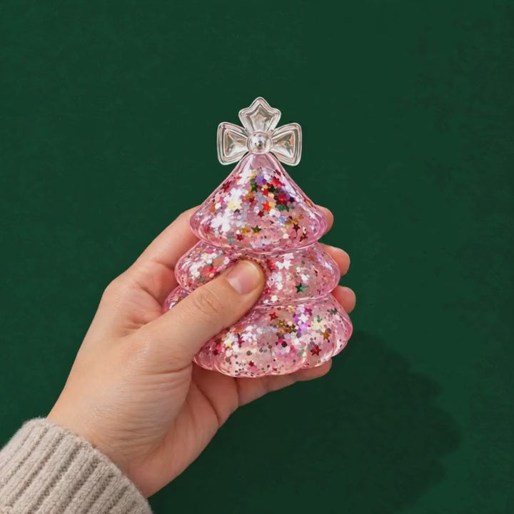 A thumb gently presses the pink Glitter Tree gel squishy and the glitter swirls