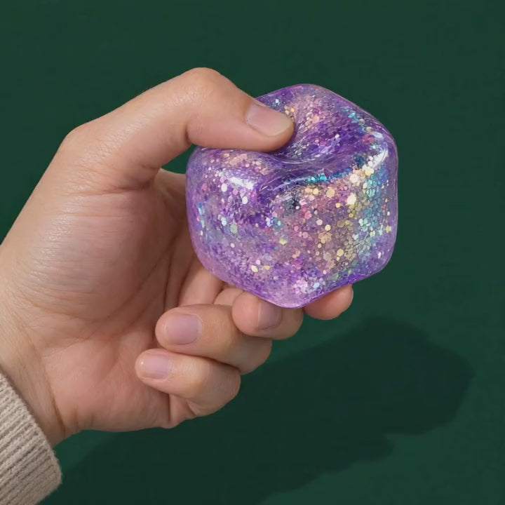 Fingers press the glitter Crystal Ice gel cube and it settles back into a cube