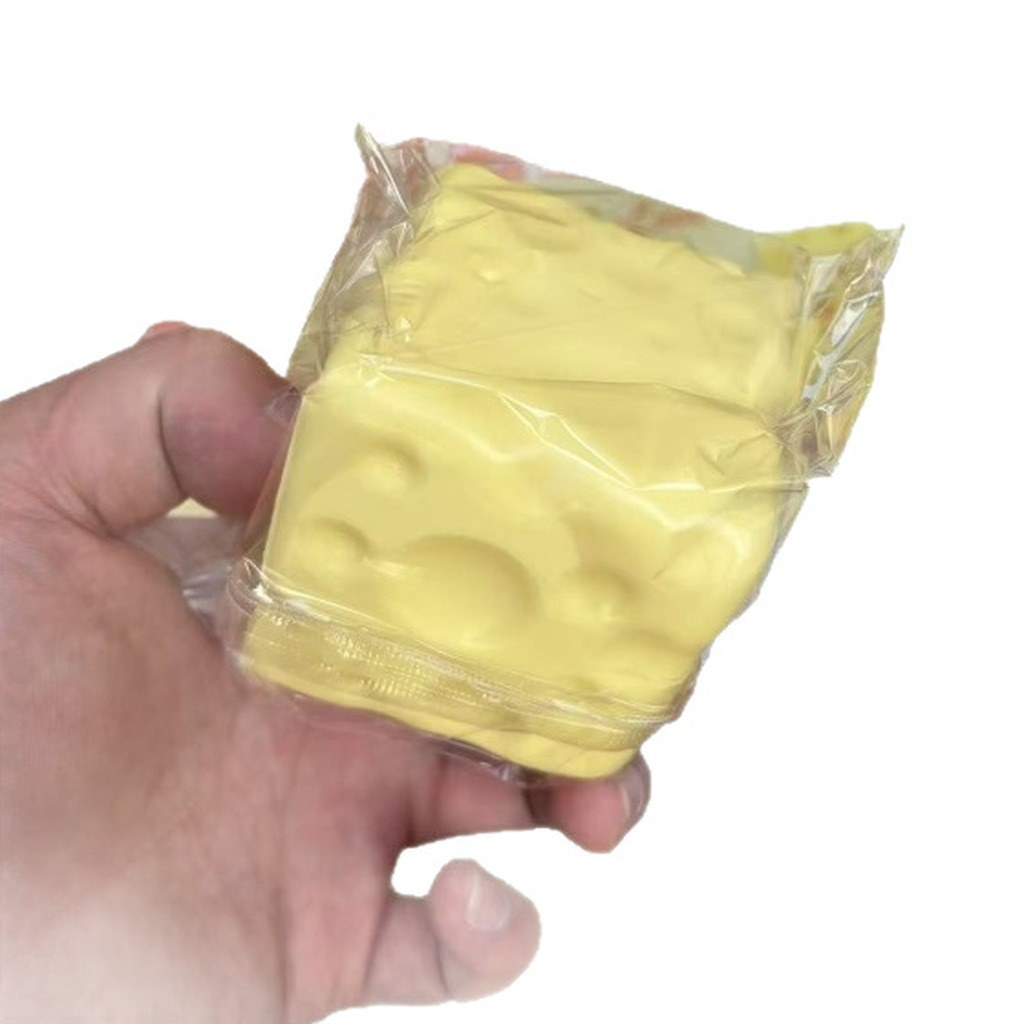Real supplier photo: the yellow Swiss-cheese squishy in its clear plastic bag, held in an adult hand