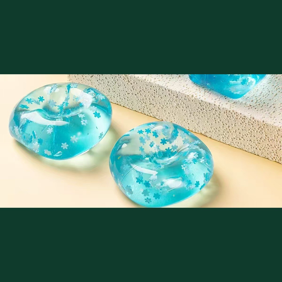Real photo: two snowflake blue cubes squashed flat into soft pillows, showing the gel is mouldable