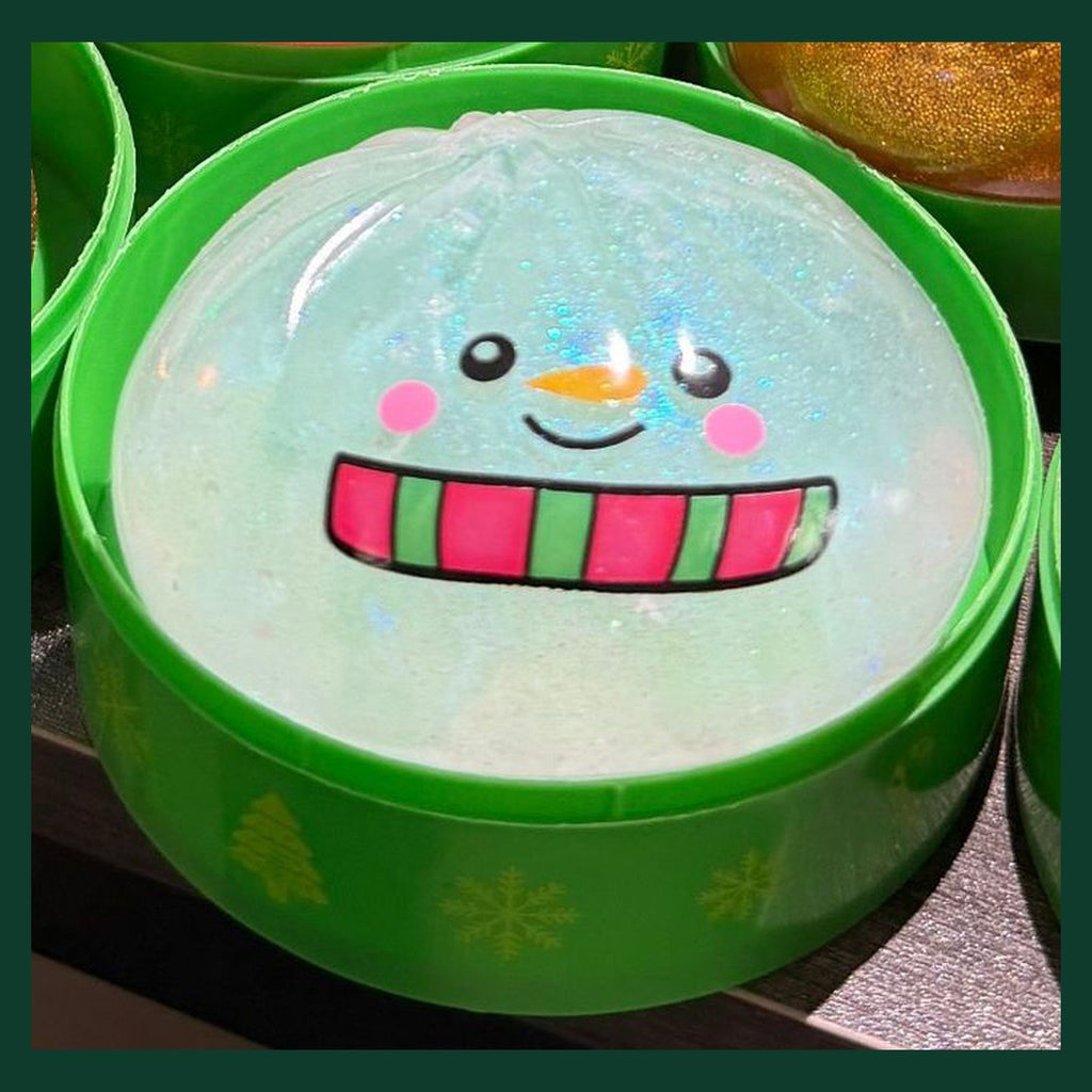 Real close-up of the Snowman bao: clear iridescent glitter gel with a printed scarf and carrot nose
